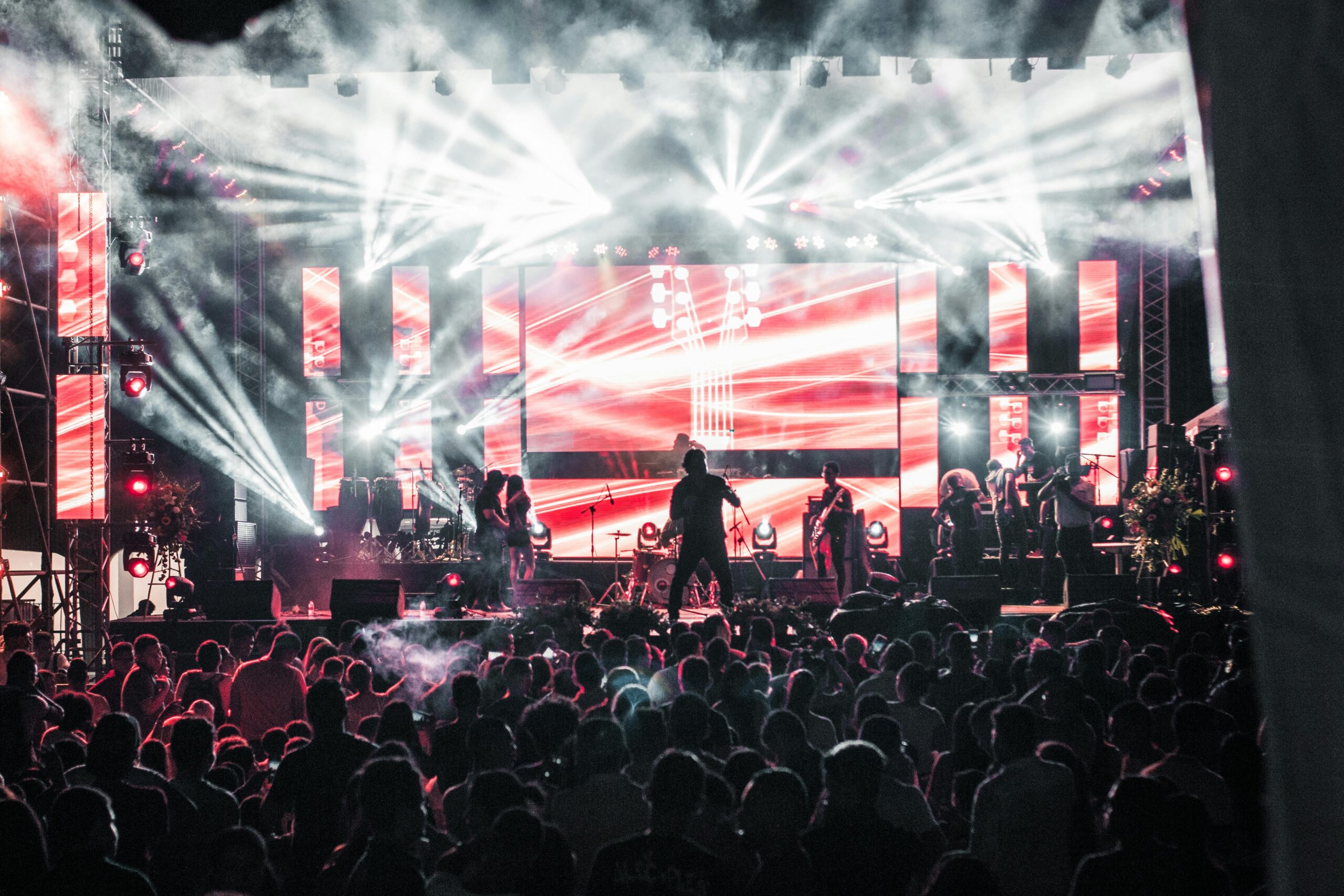 Crowd at an alternative Arabic music concert with dramatic lights and modern indie atmosphere