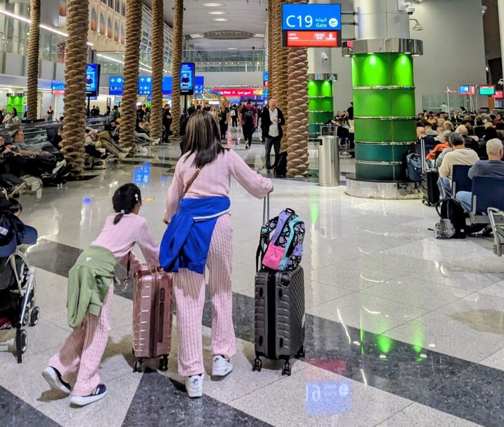 Women travelling through an airport with luggage during an international trip