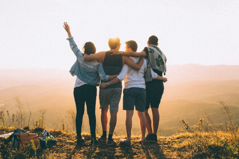 Group of adult friends standing together at sunset symbolising connection, friendship, and social life in a new city