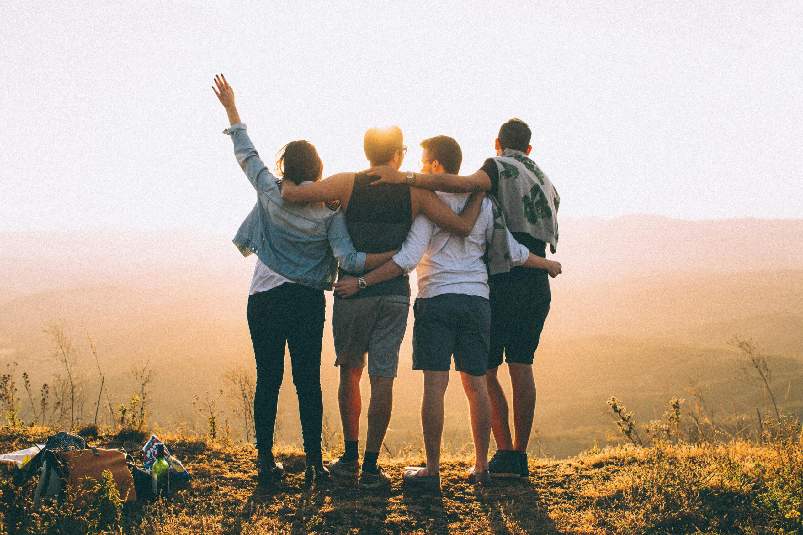 Group of adult friends standing together at sunset symbolising connection, friendship, and social life in a new city