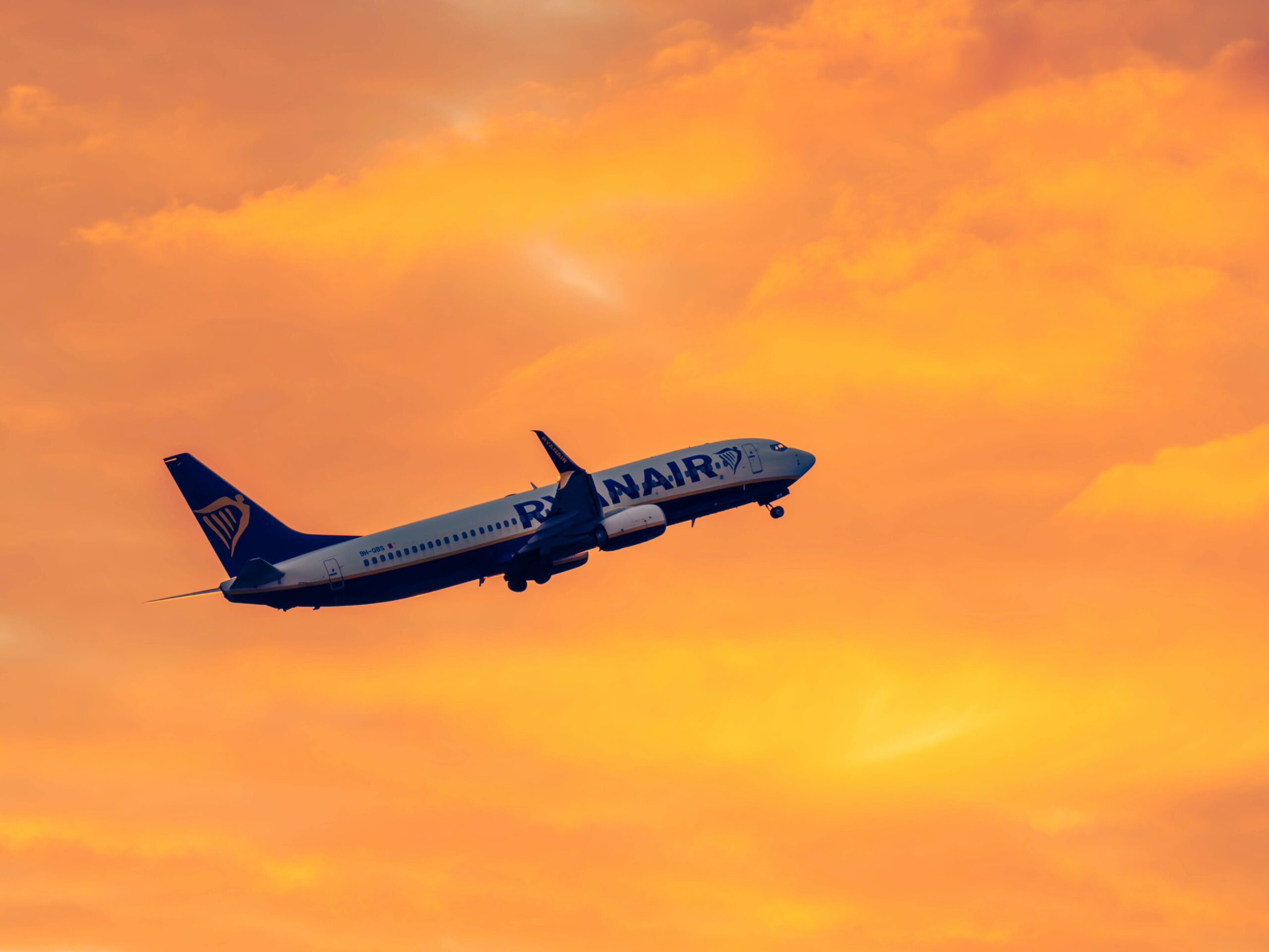 Ryanair airplane flying during sunset with orange sky background