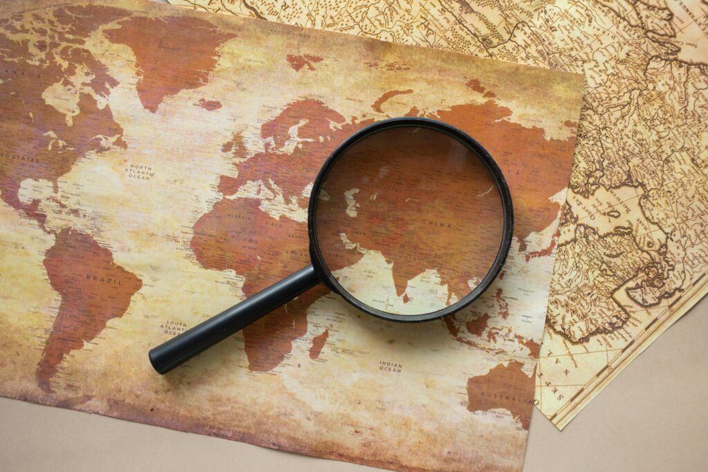 World map and magnifying glass representing research on digital nomad visa available countries