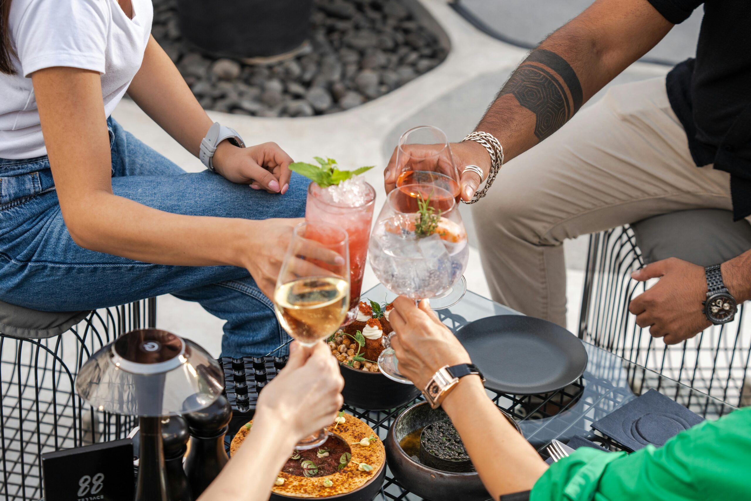 Expats socialising with cocktails at a rooftop bar in Dubai