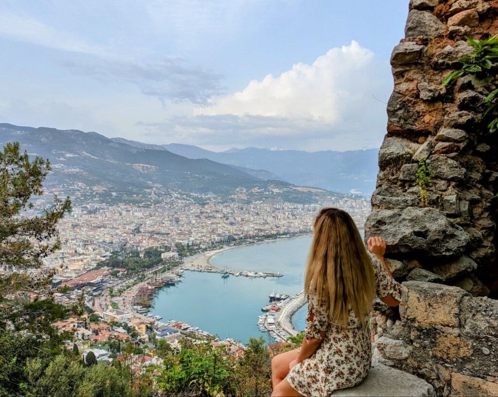 Woman overlooking the coastline and mountains in Alanya, Turkey during solo travel