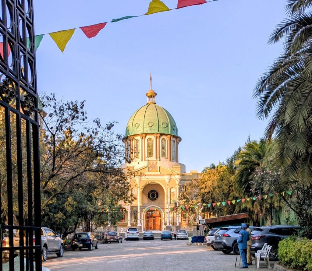 Holy Trinity Cathedral in Addis Ababa, Ethiopia surrounded by palm trees and historic architecture
