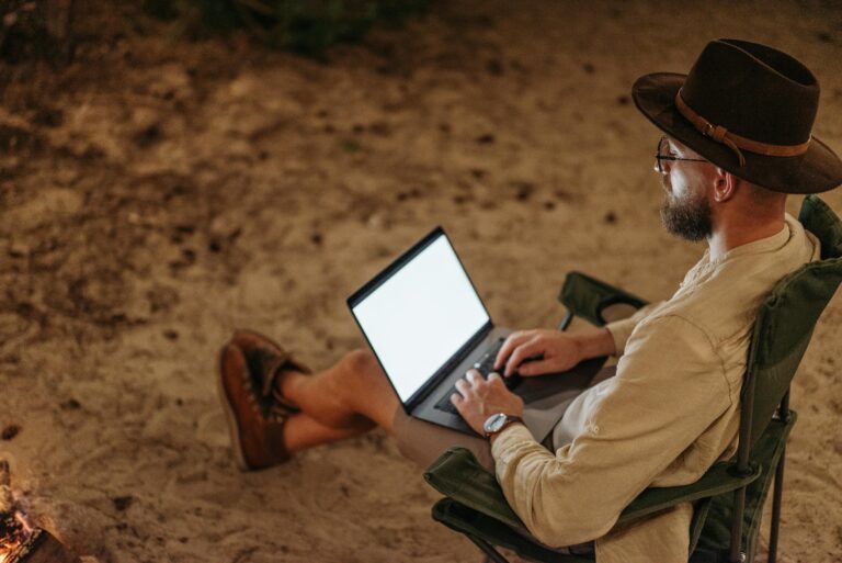 Digital nomad working remotely outdoors with a laptop while travelling and living a location-independent lifestyle