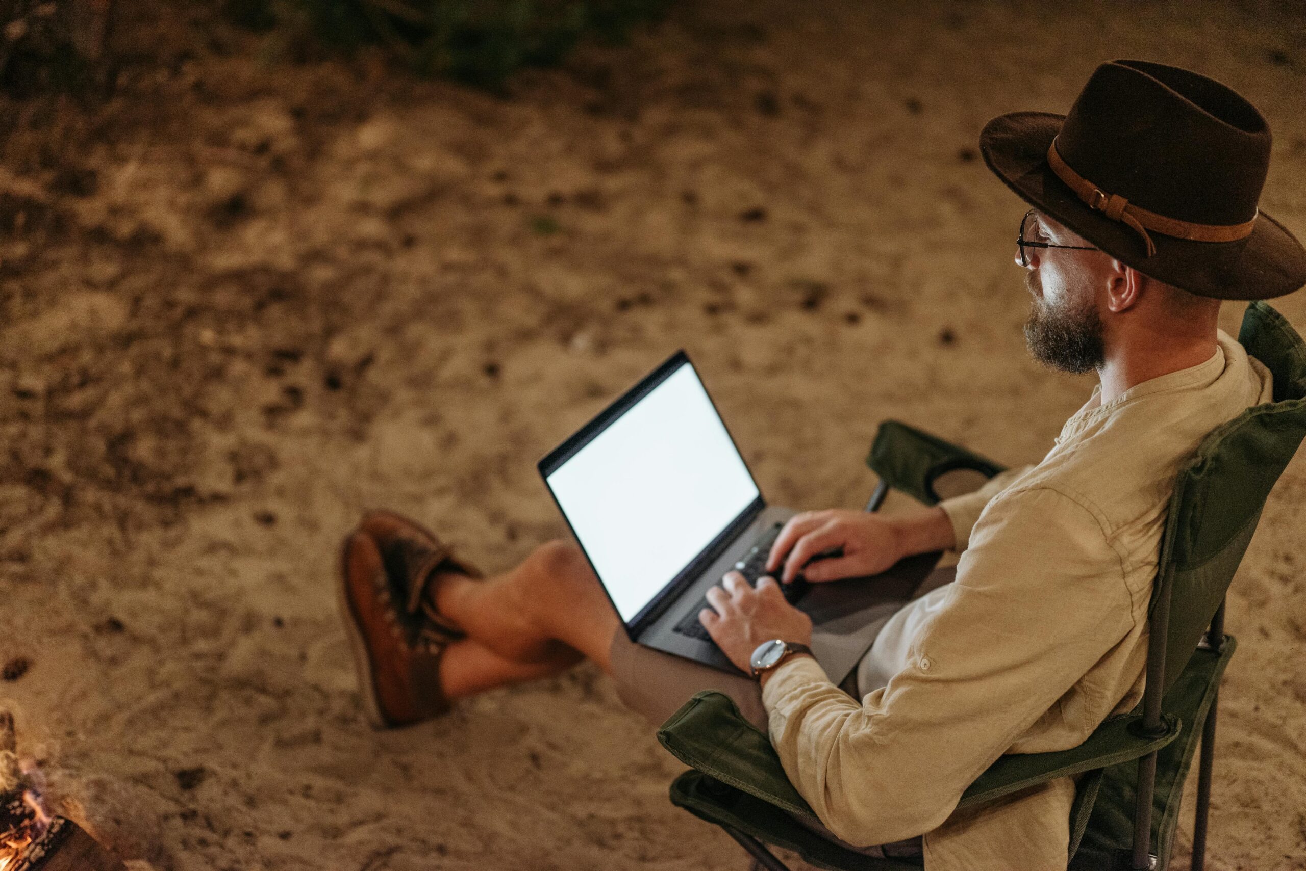 Digital nomad working remotely outdoors with a laptop while travelling and living a location-independent lifestyle