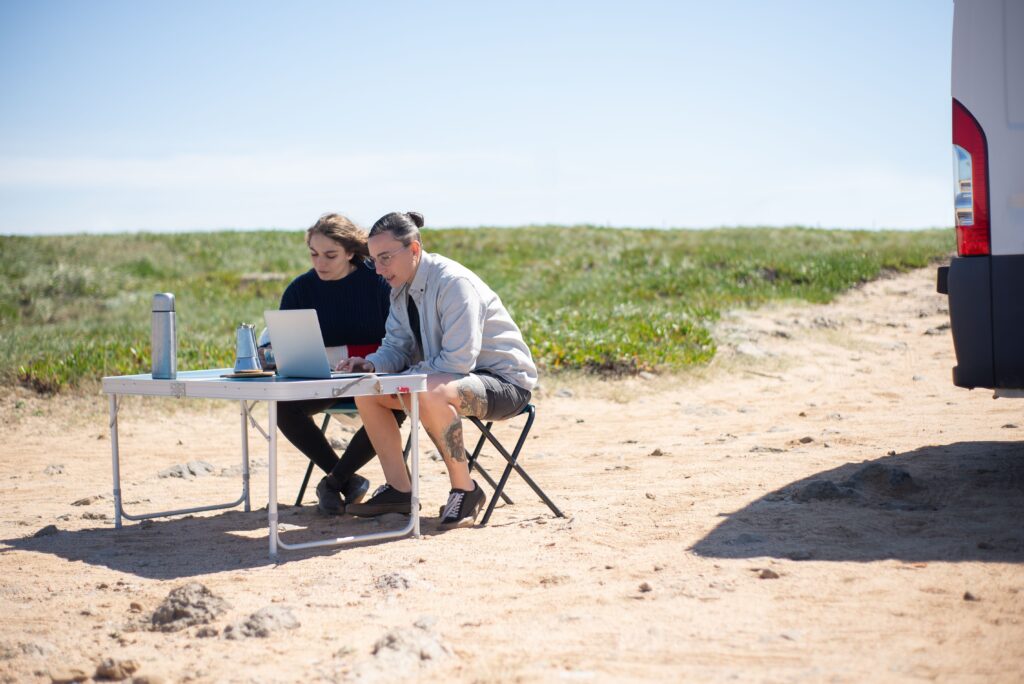 Digital nomads working remotely outdoors with a laptop while travelling and maintaining a location-independent career