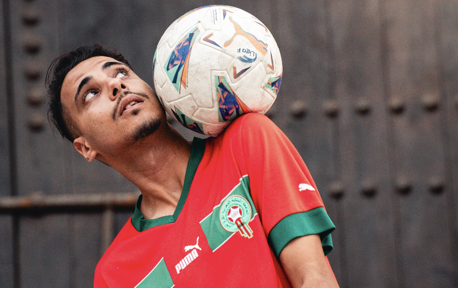 Moroccan football fan balancing a football while wearing the Morocco national team jersey