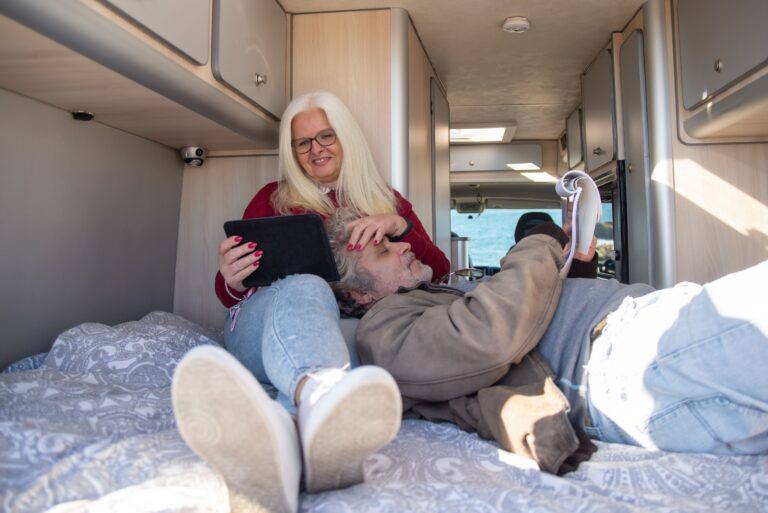 Retired couple relaxing inside a motorhome, enjoying the freedom of the Grey Nomad lifestyle.