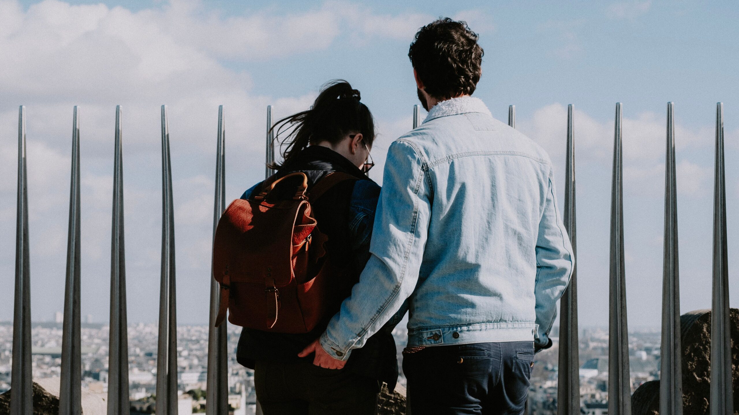Couple standing together overlooking a city during a trip, representing a travel romance and the emotional connections formed while travelling.