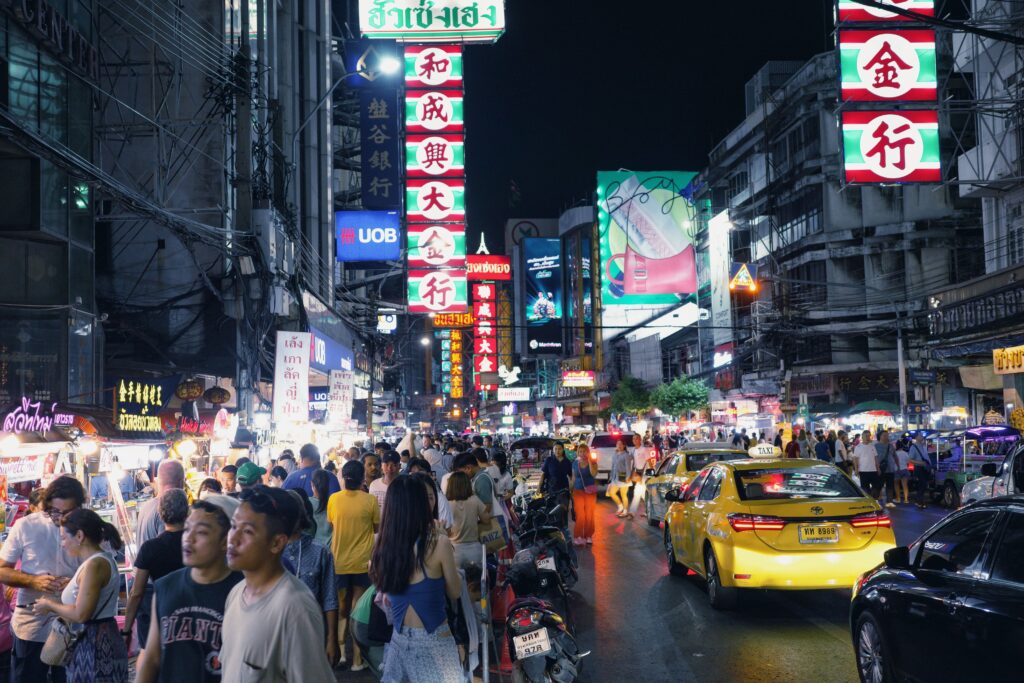 Busy street in Bangkok's Chinatown at night, a vibrant and affordable destination popular with digital nomads and remote workers.