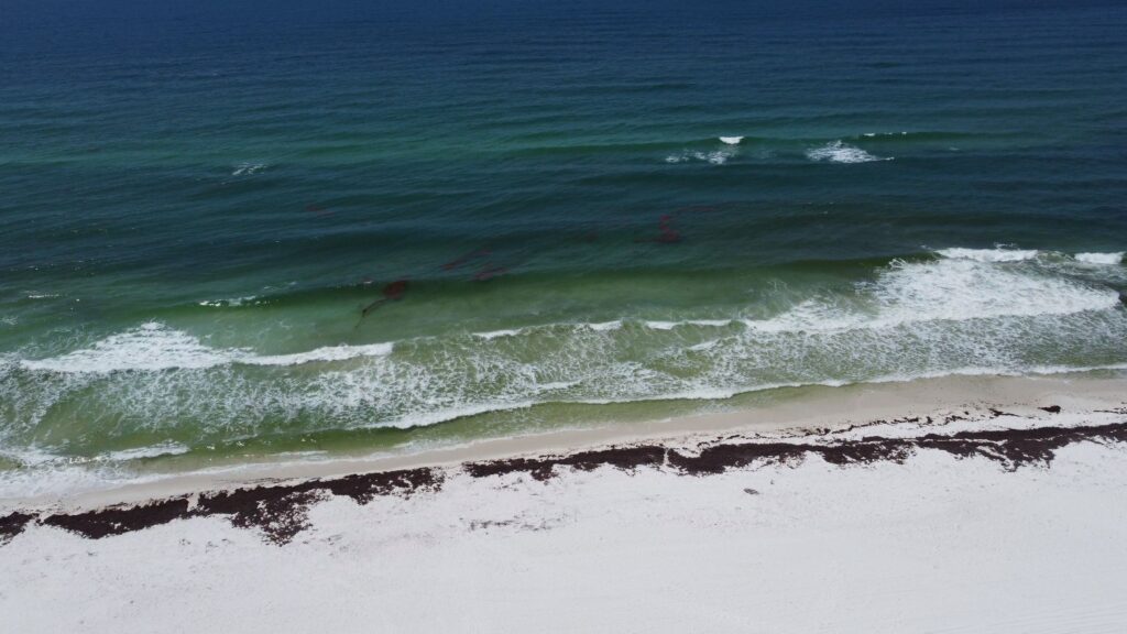 Aerial view of the white-sand beaches and emerald-green water along Florida's Emerald Coast in Destin