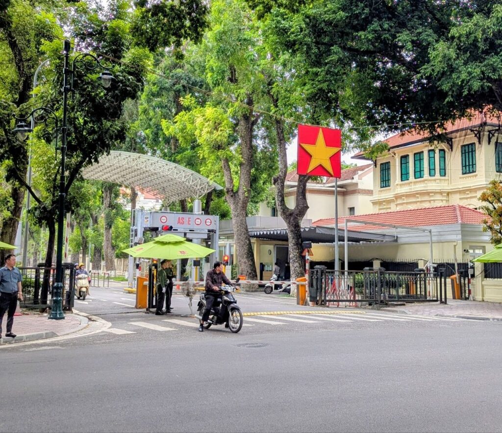 Tree-lined street in Hanoi, Vietnam, featuring French colonial architecture, a Vietnamese flag, and a peaceful neighborhood popular with expats.