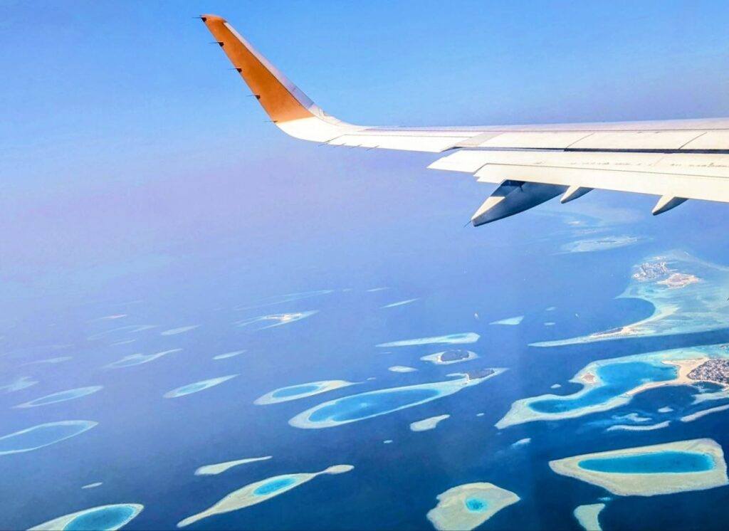 Aerial view of the Maldives islands from an airplane window during a flight from Dubai to Malé.