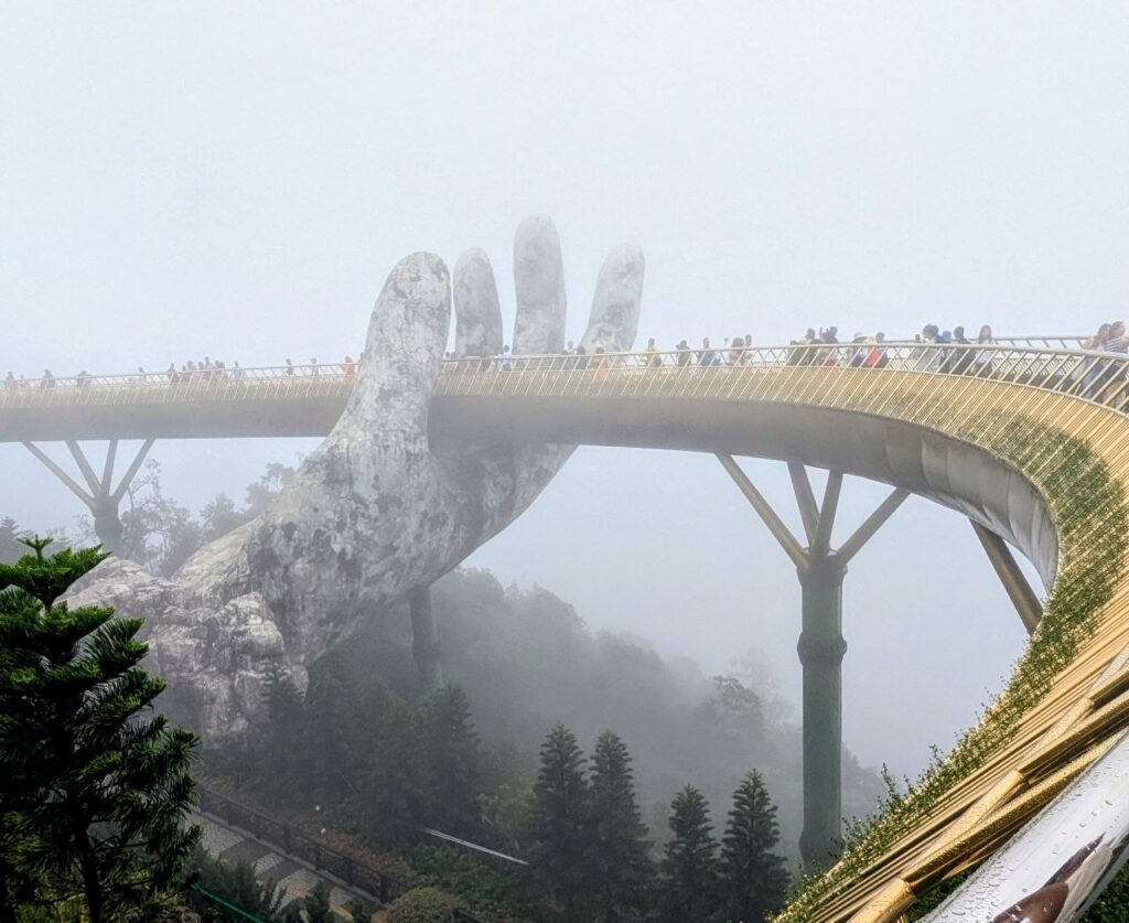 Golden Bridge at Ba Na Hills covered in dense fog during rainy weather in late September, Da Nang, Vietnam