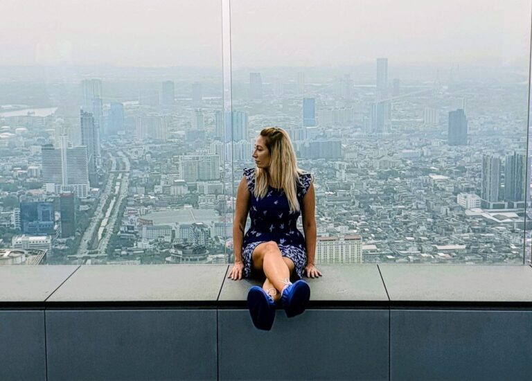 Author overlooking the Bangkok skyline from a rooftop observation deck during a visit to the city