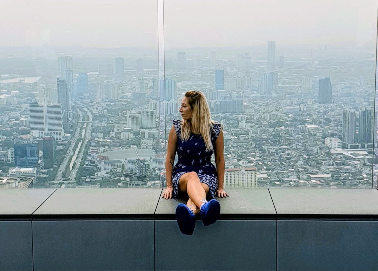 Author overlooking the Bangkok skyline from a rooftop observation deck during a visit to the city