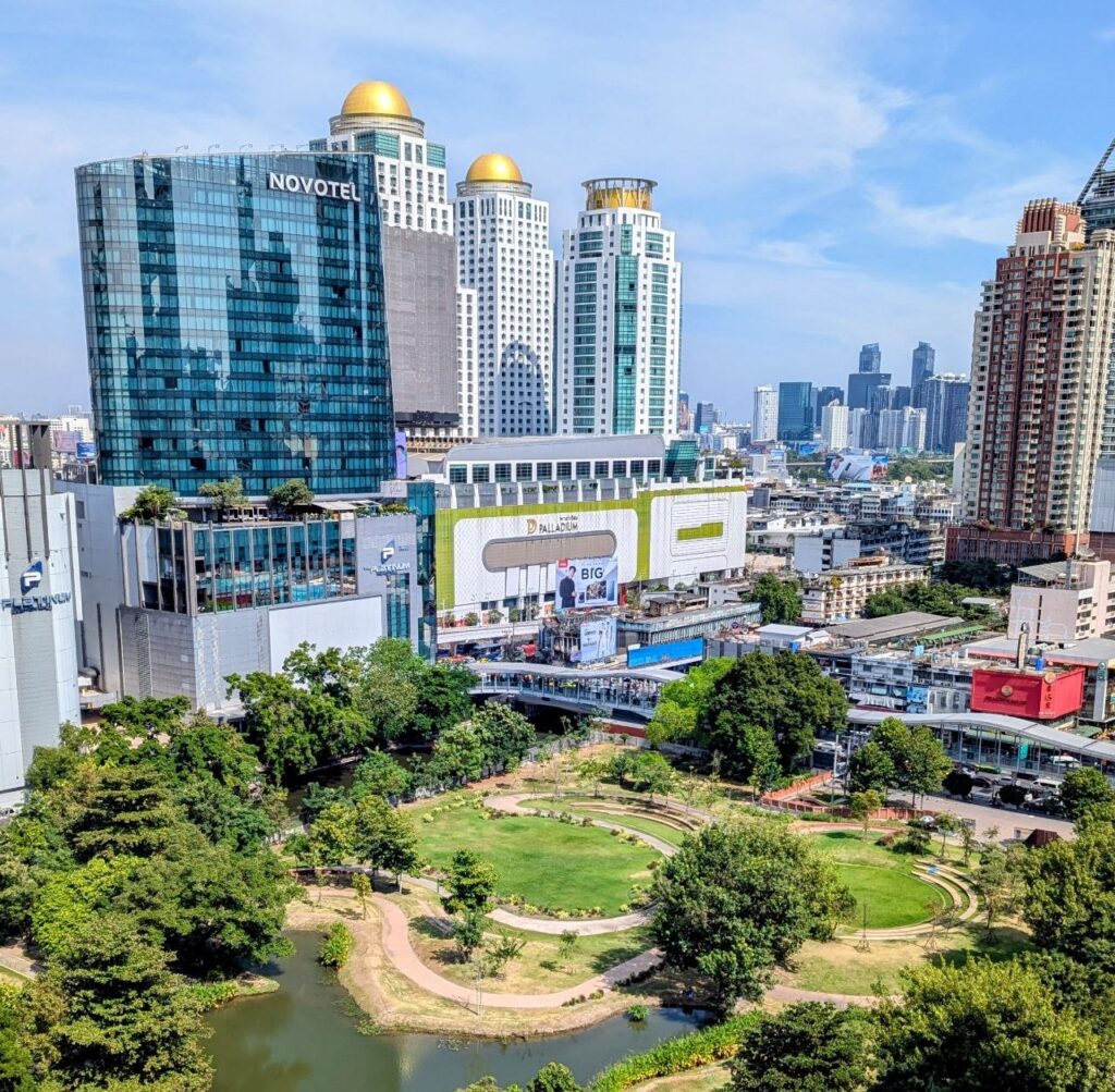 View of Benjakitti Park surrounded by modern high-rise buildings in Bangkok's Asoke business district
