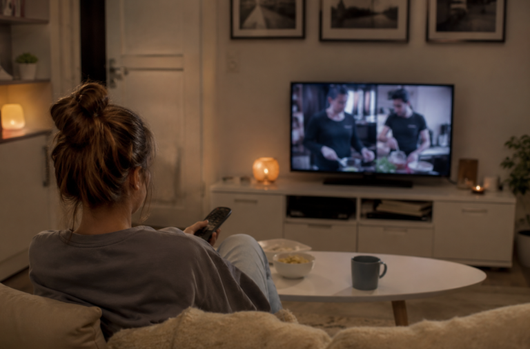 Girl sitting alone at home on a weekend watching TV