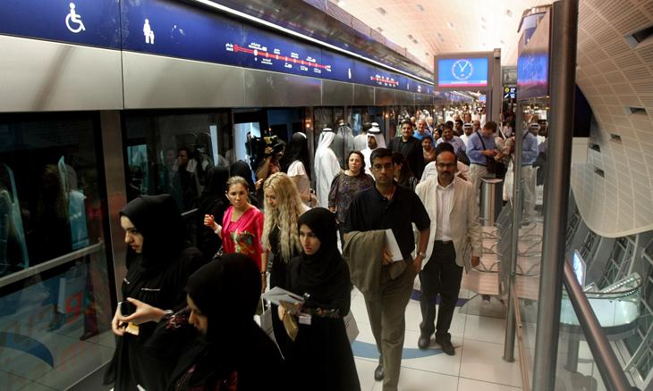 Crowded Dubai Metro platform with commuters during a busy period