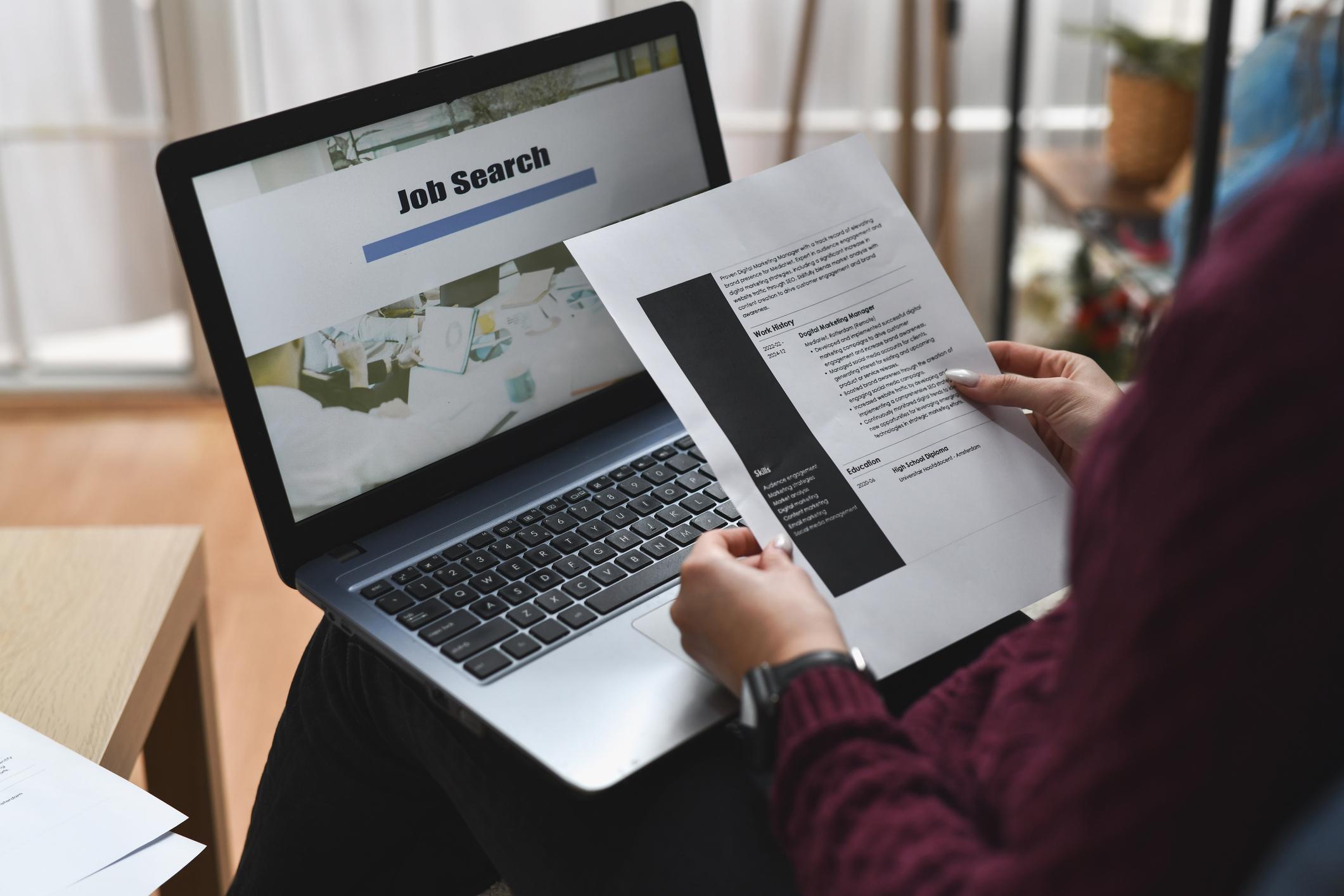 Job seeker reviewing a CV while searching for jobs online