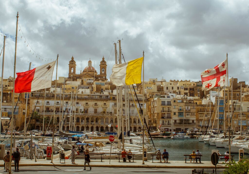 View of Valletta and the Grand Harbour with traditional boats and Maltese flags