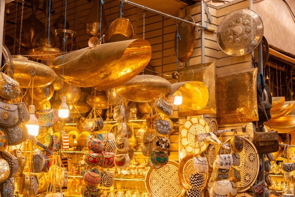 Gold-colored metalware and traditional decorative items displayed at a Dubai market
