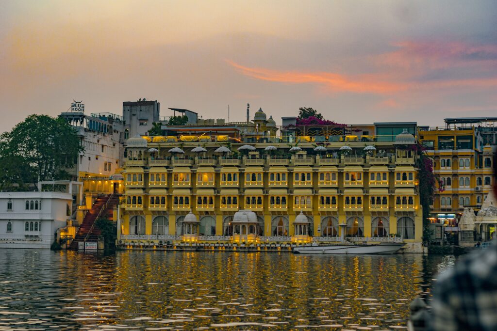 Historic lakeside buildings in Udaipur, Rajasthan, India, at sunset.