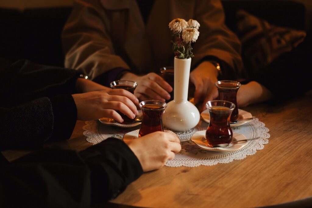 People drinking traditional Turkish tea together from tulip-shaped glasses