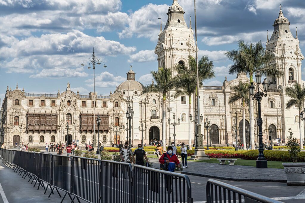 Historic cathedral and colonial architecture in Lima, Peru, with palm trees and people in the city center