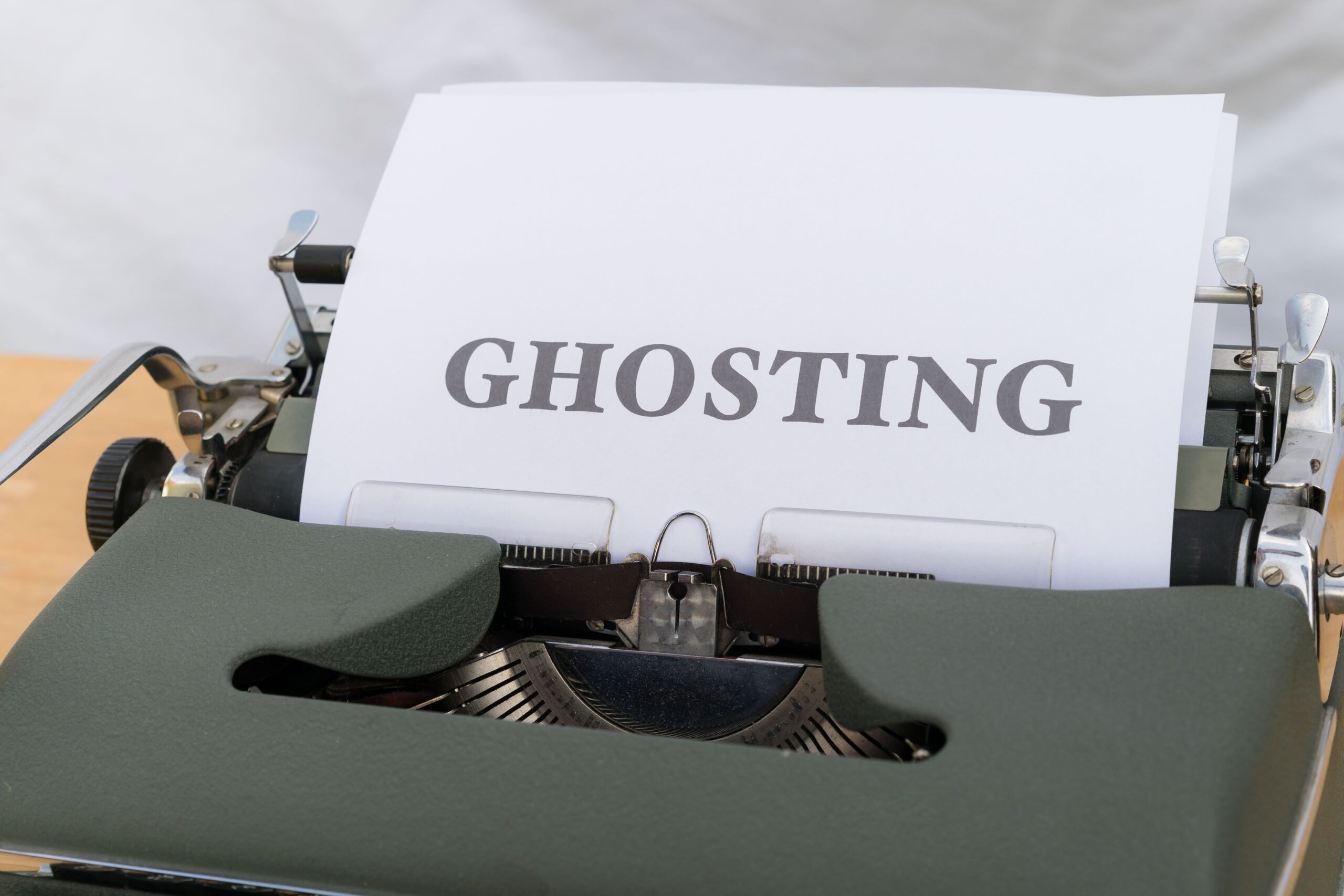 The word "Ghosting" typed on a vintage typewriter, symbolizing sudden silence and disappearing communication in modern dating.