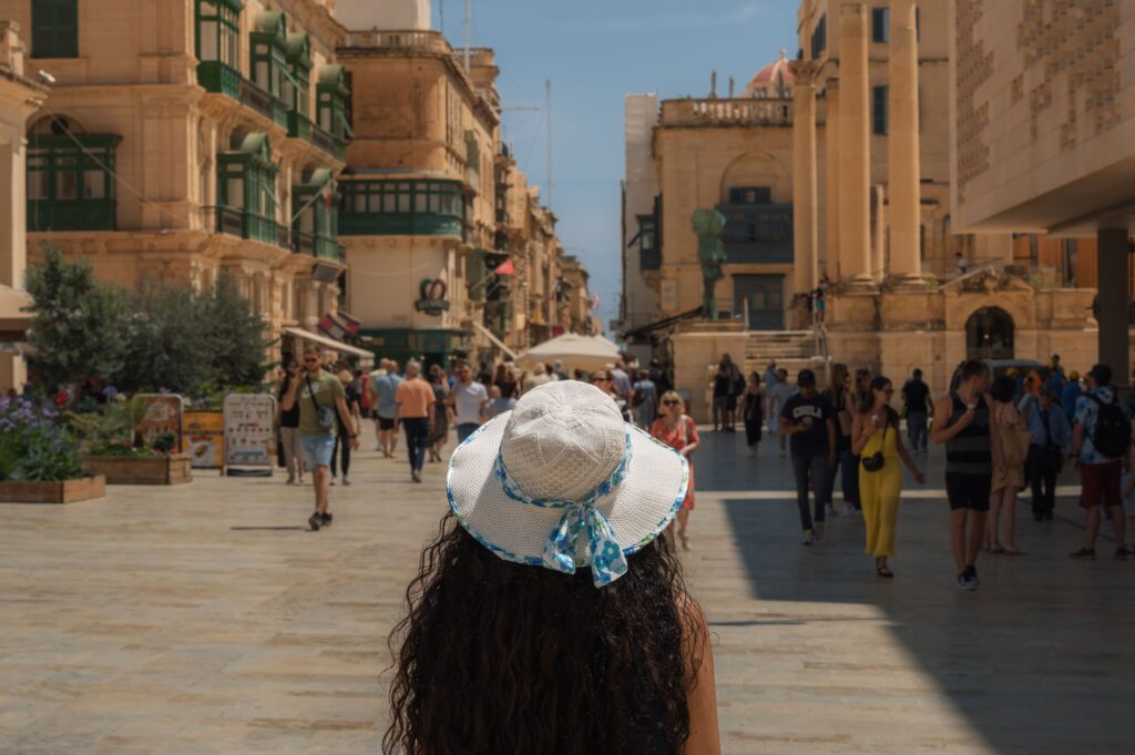 Tourists walking through a busy street in Valletta, Malta during the summer tourist season