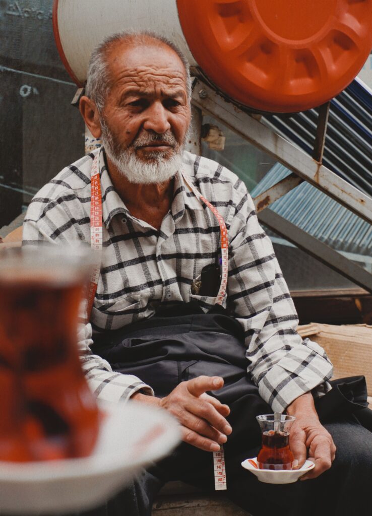 Turkish man drinking traditional tea from a tulip-shaped glass
