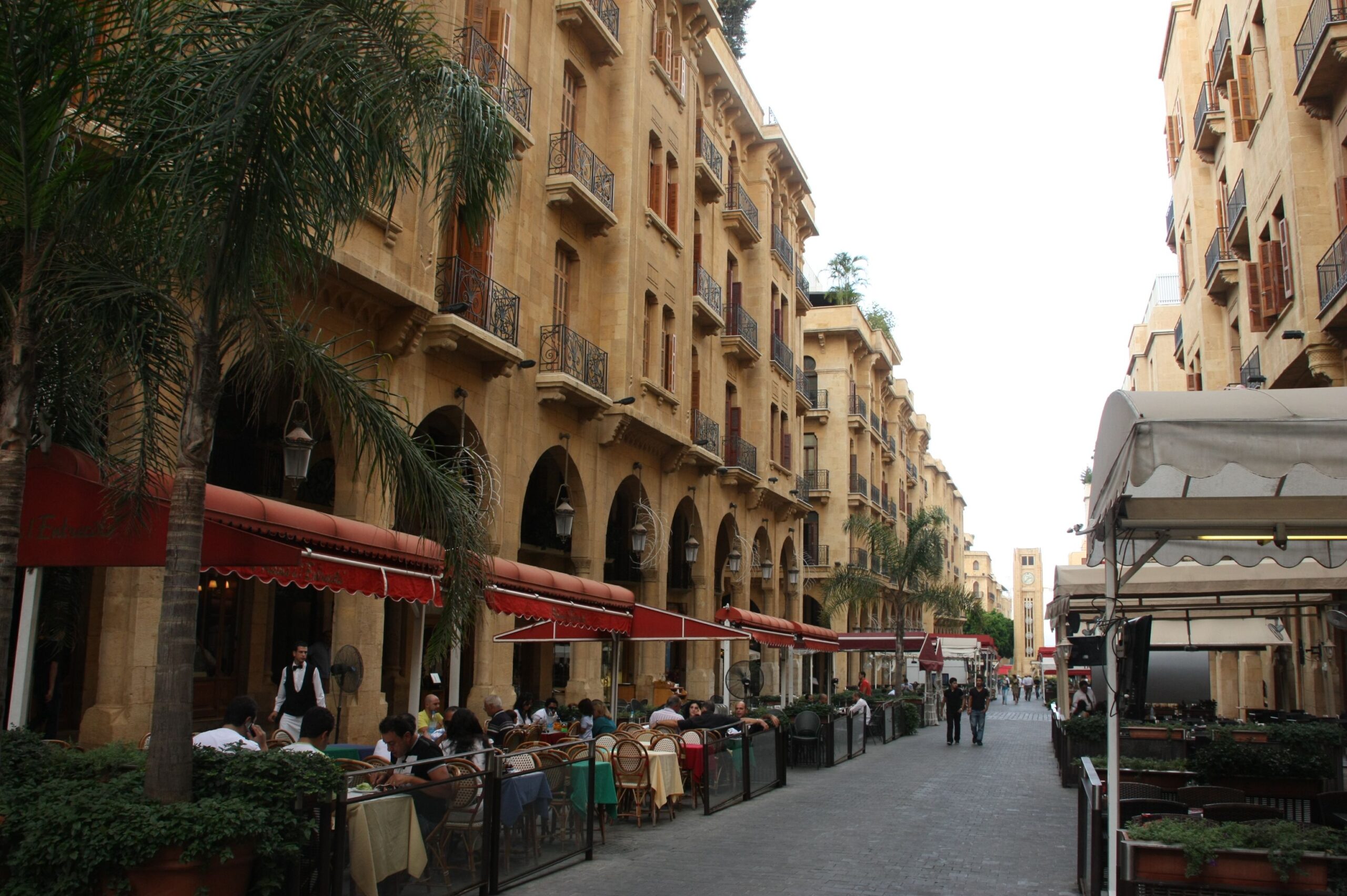 Pedestrian street in downtown Beirut lined with cafés, restaurants and historic sandstone buildings.
