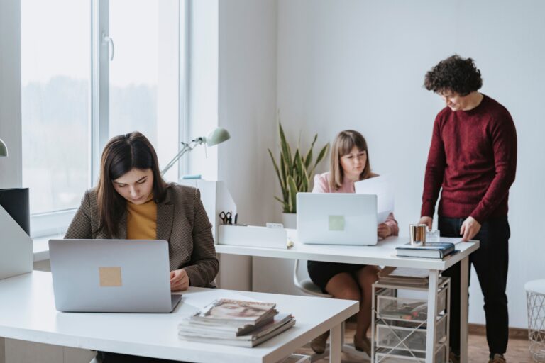 Coworker sitting alone while colleagues talk in the office
