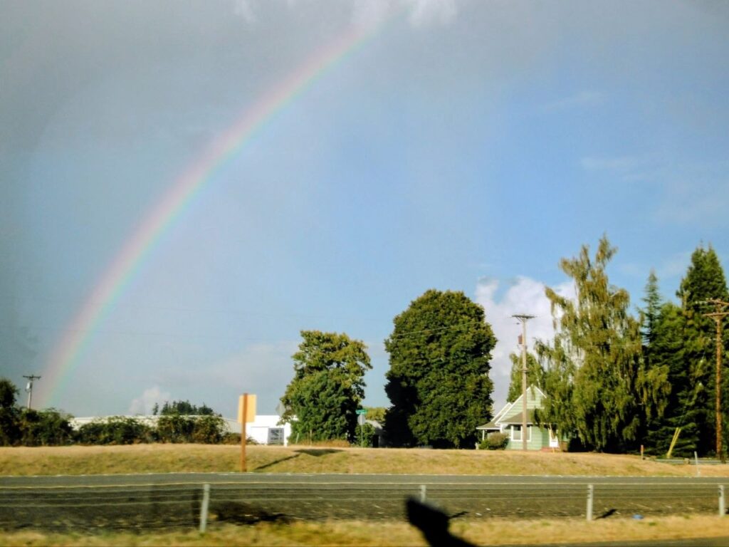 Rainbow appearing between rain clouds and blue sky in Portland, Oregon